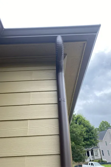 Front view of a brown gutter downspout attached to a home in the Atlanta, GA area by Whitaker Roofing.
