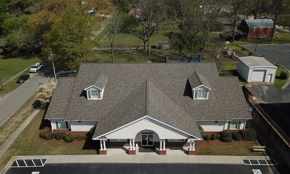 overhead view of white business building with gray shingle roof right outside an Alpharetta neighborhood